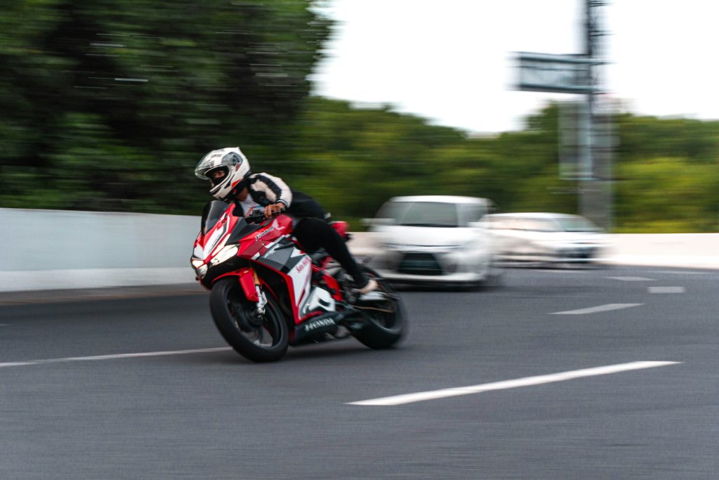 moto rouge qui double une voiture