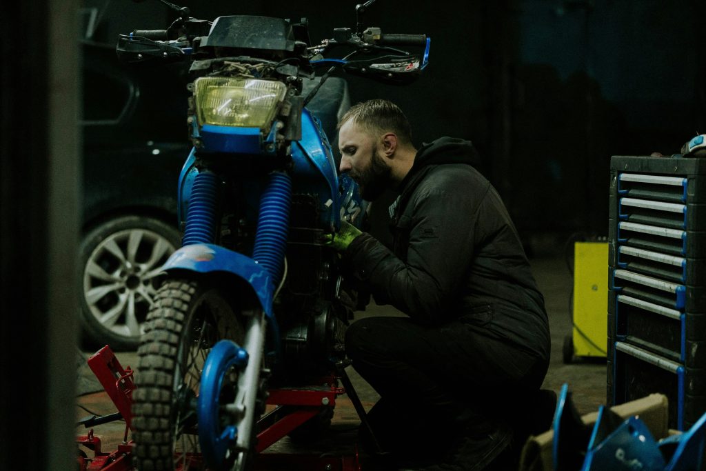 homme qui fait l'entretien de sa moto