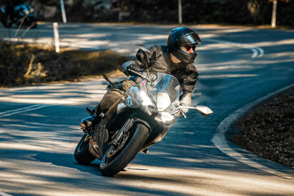 Motard qui prend un virage, le regard loin