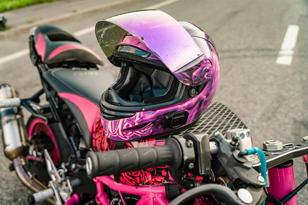 Moto rose avec casque rose posé sur le réservoir
