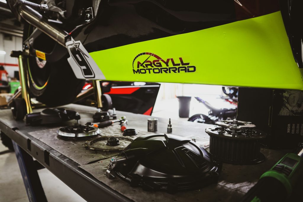 dessous de moto posée sur un pont de mécanique