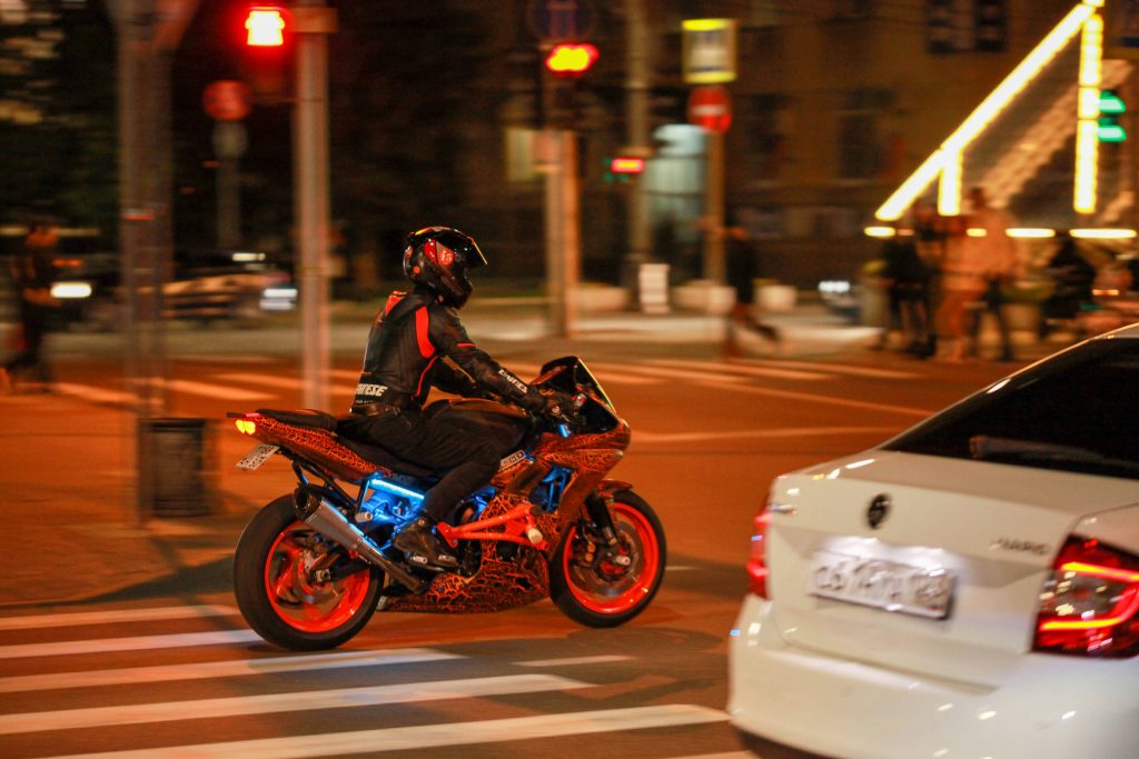 Motard qui roule en ville de nuit, très visible